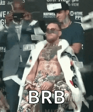 a man in a fur coat is sitting in a chair with the word brb on his chest .