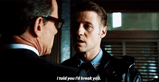 a man in a police uniform talks to another man in a suit