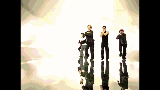 a group of men are dancing in front of a white wall