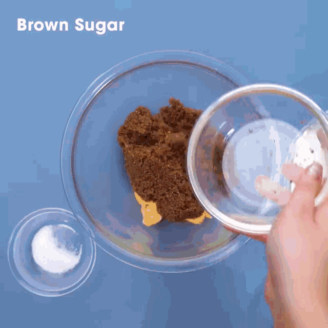 a bowl of brown sugar is being stirred with a spatula