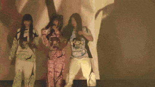 three women are standing next to each other on a stage in front of a projector screen .