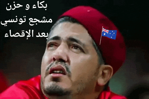 a man wearing a red beret with a small flag on it