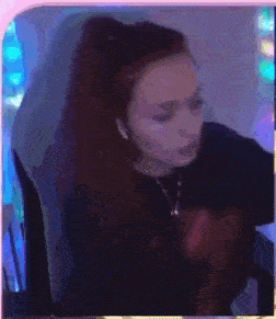 a woman is wearing headphones and a ponytail while sitting in front of a computer .