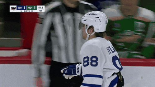 a hockey player wearing number 88 talks to a referee