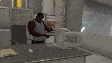 a man in a white tank top is standing in front of a computer monitor