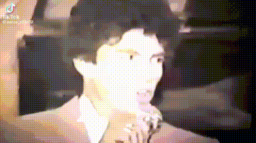 a close up of a man 's face with a blurred background in a video .