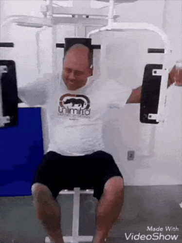 a man wearing a ecko unltd shirt is sitting on a machine