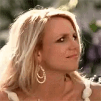 a close up of a woman wearing hoop earrings and a white dress .