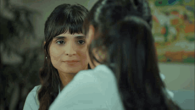 two women looking at each other in a mirror