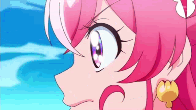 a close up of a girl with pink hair and earrings .