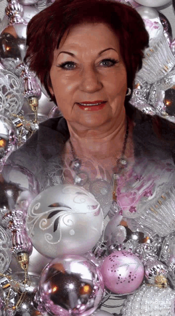 a woman surrounded by pink and silver christmas decorations
