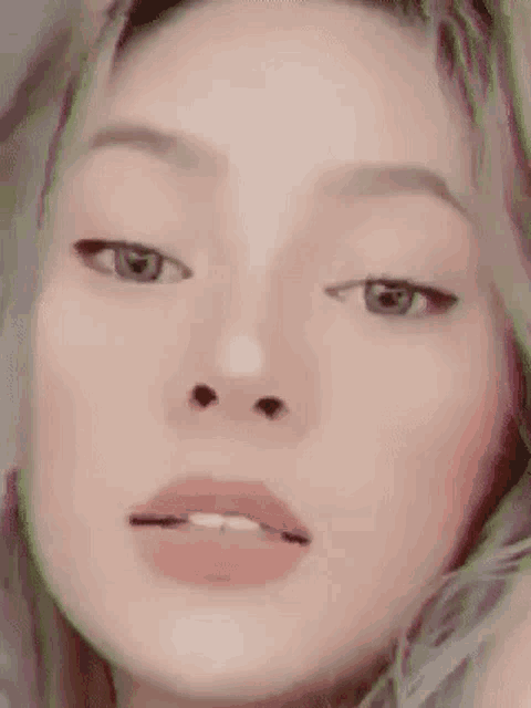 a close up of a woman 's face with her eyes closed and her mouth open .
