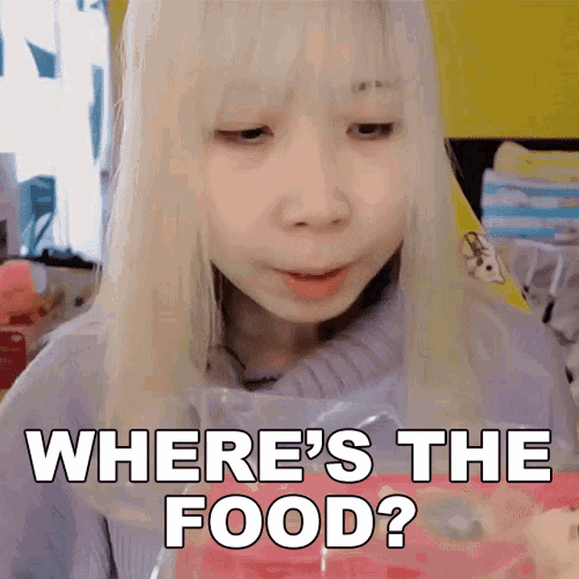 a girl with blonde hair is holding a bag of food and asking where 's the food