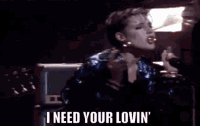 a woman is singing into a microphone and says i need your lovin ' .