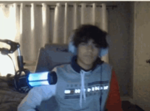 a young man wearing headphones and a tommy hilfiger shirt