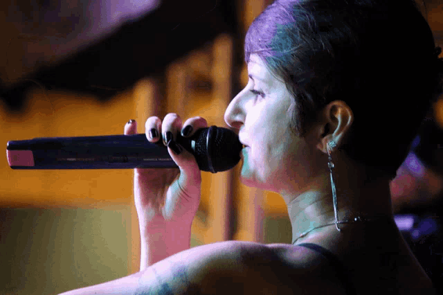 a woman singing into a microphone with the word sennheiser on it