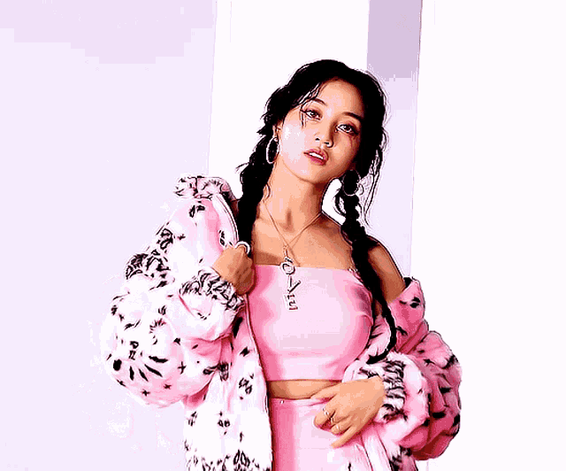 a woman wearing a pink crop top and a pink jacket