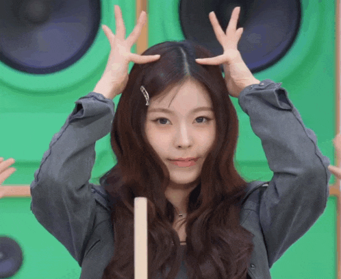 a girl with long hair is making a funny face with her hands on her head