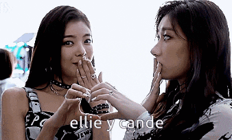 two women are standing next to each other and one of them is kissing the other .