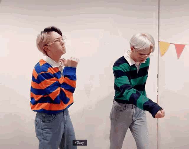 two men are standing next to each other and one of them is saying okay
