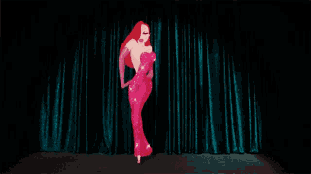 a woman in a red dress and gloves is dancing on a stage in front of a blue curtain .