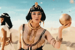 a woman dressed as a pharaoh is holding a ball in her hand .