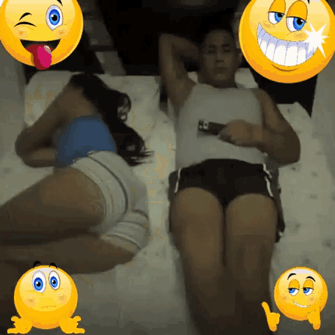 a couple laying on a bed with smiley faces around them