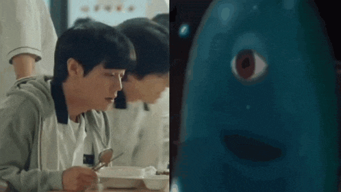 a man is sitting at a table with a spoon in his hand next to a blue monster .