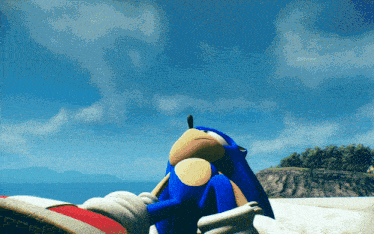a sonic the hedgehog sitting on a beach with mountains in the background