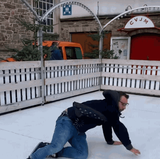 a man is kneeling on the ice near cvjm