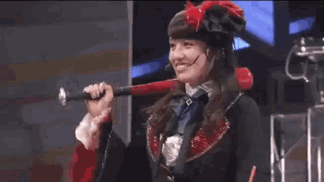 a woman is wearing a hat and holding a red flag .