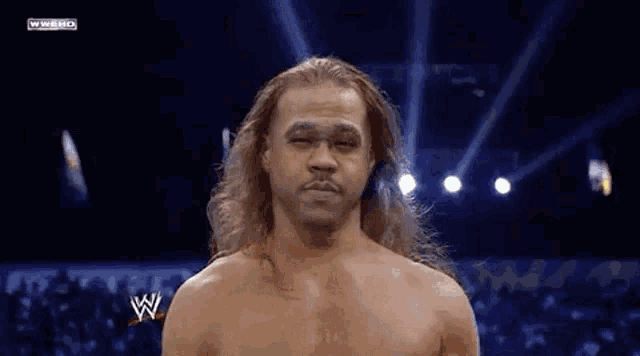a man with long hair is standing in front of a crowd and says you can leave now