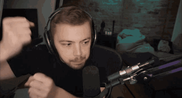 a man wearing headphones is dancing in front of a microphone