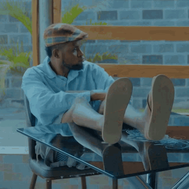 a man sits at a table with his legs crossed