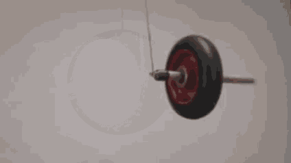 a close up of a yoyo hanging from a string on a wall .