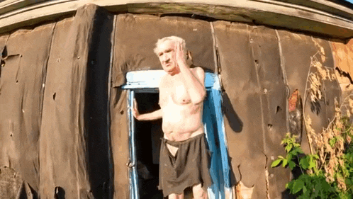 a shirtless man is standing in front of a building