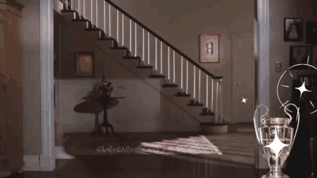 a woman is dancing in front of a staircase and a trophy that says " when i am "