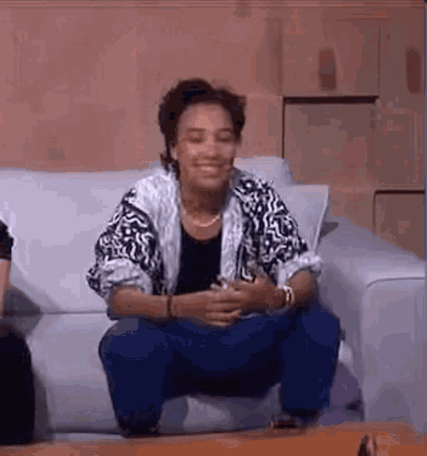 a woman is sitting on a couch with her legs crossed .