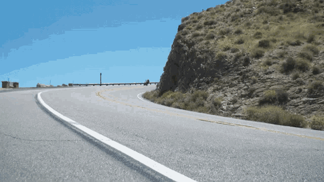 a curve in a road with a yellow line on it