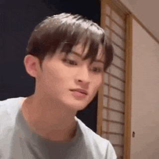 a close up of a young man 's face making a funny face in a room .