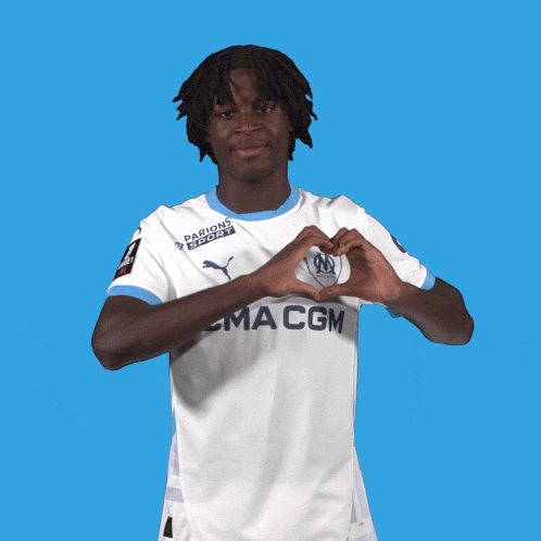 a soccer player wearing a ma cgm jersey makes a heart shape with his hands