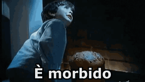 a little boy is standing in front of a fireplace looking up at a cake .