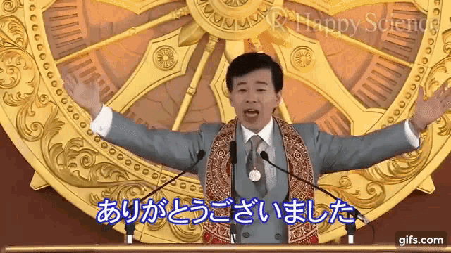 a man stands in front of a clock with his arms outstretched and says happy science in a foreign language .
