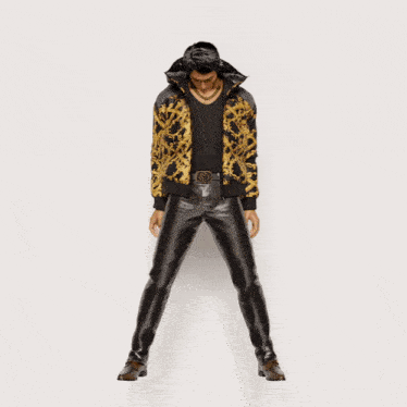 a man in a black shirt and leather pants is dancing with his arms outstretched