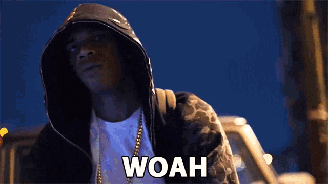 a man in a hoodie says woah with his hands together
