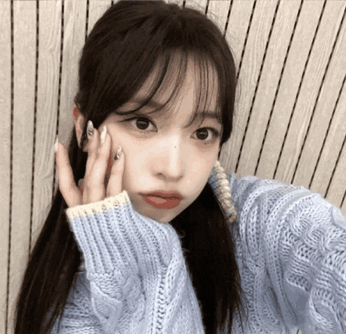a girl wearing a blue sweater takes a selfie