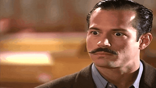 a man with a mustache is looking at something