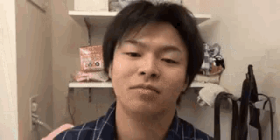 a young man is making a funny face in a bathroom .