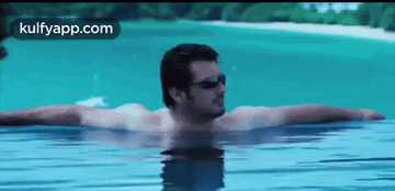 a shirtless man is swimming in a swimming pool .