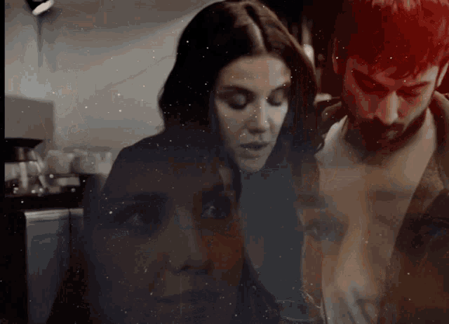 a man and a woman are looking at each other in a dark room